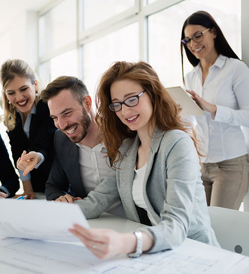 4 people smiling at a laptop screen