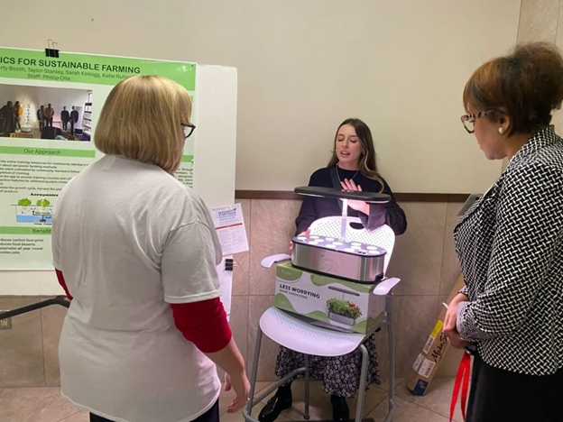 two women watching a research demonstration of a hydroponic system